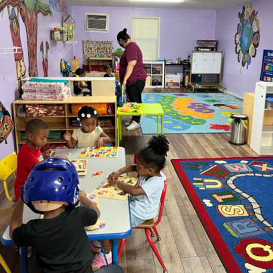 Children learning puzzles at a table.